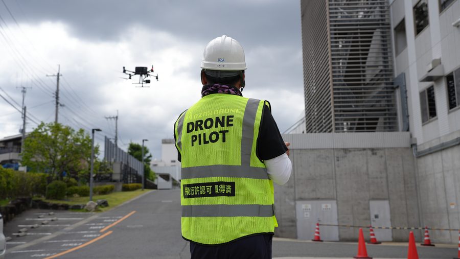 飛行許認可取得済のベストを着たドローンパイロットの運航風景